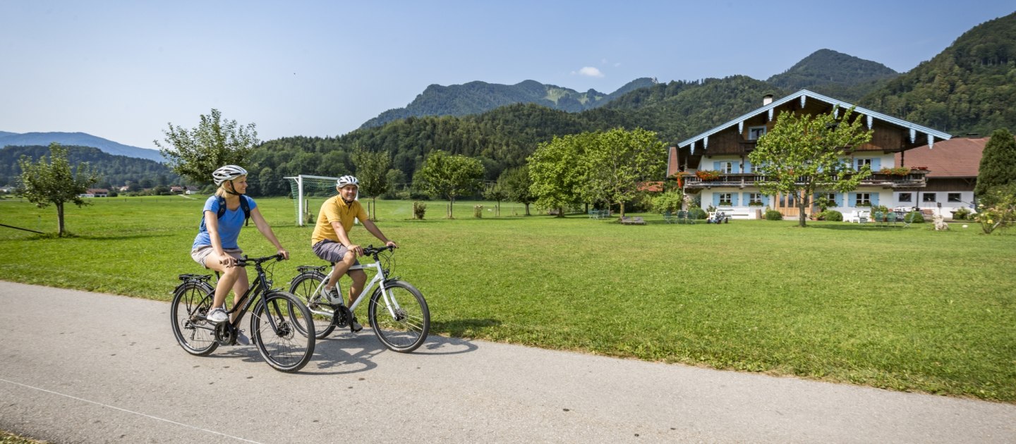 Radfahrer in Grassau im Chiemgau mit Blick auf die Berge., © Chiemgau Tourismus