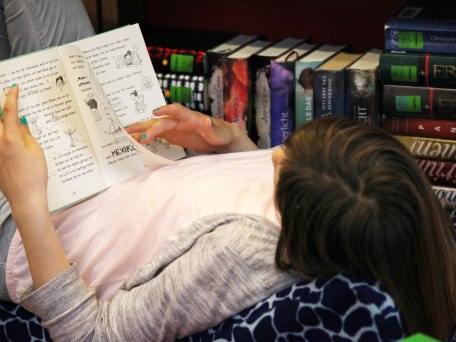 Mädchen liest ein Buch in der Gemeindebücherei Grassau